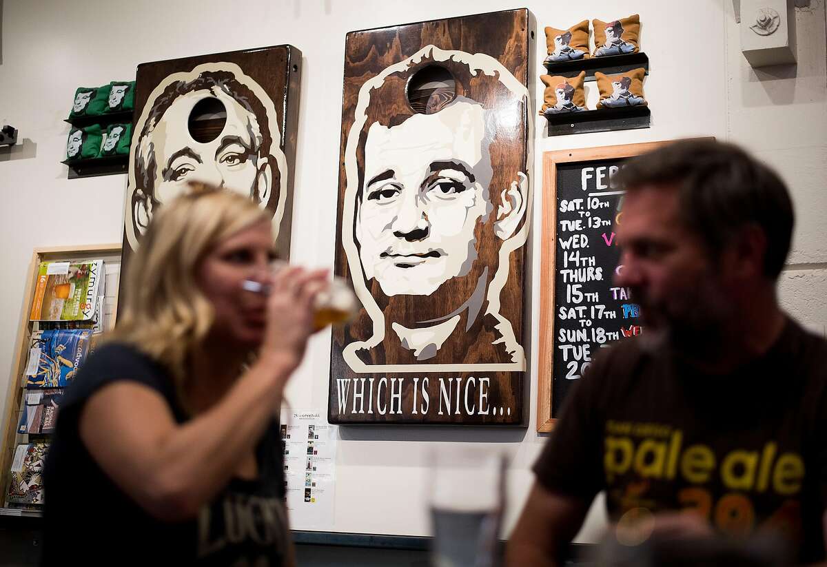 Images of actor Bill Murray, adorning a set of cornhole boards, peer down at Tannery Bend Beerworks patrons in Napa, Calif., on Saturday, Feb. 17, 2018. Seated are Marlow Bruce, left, and Mike Daniel.