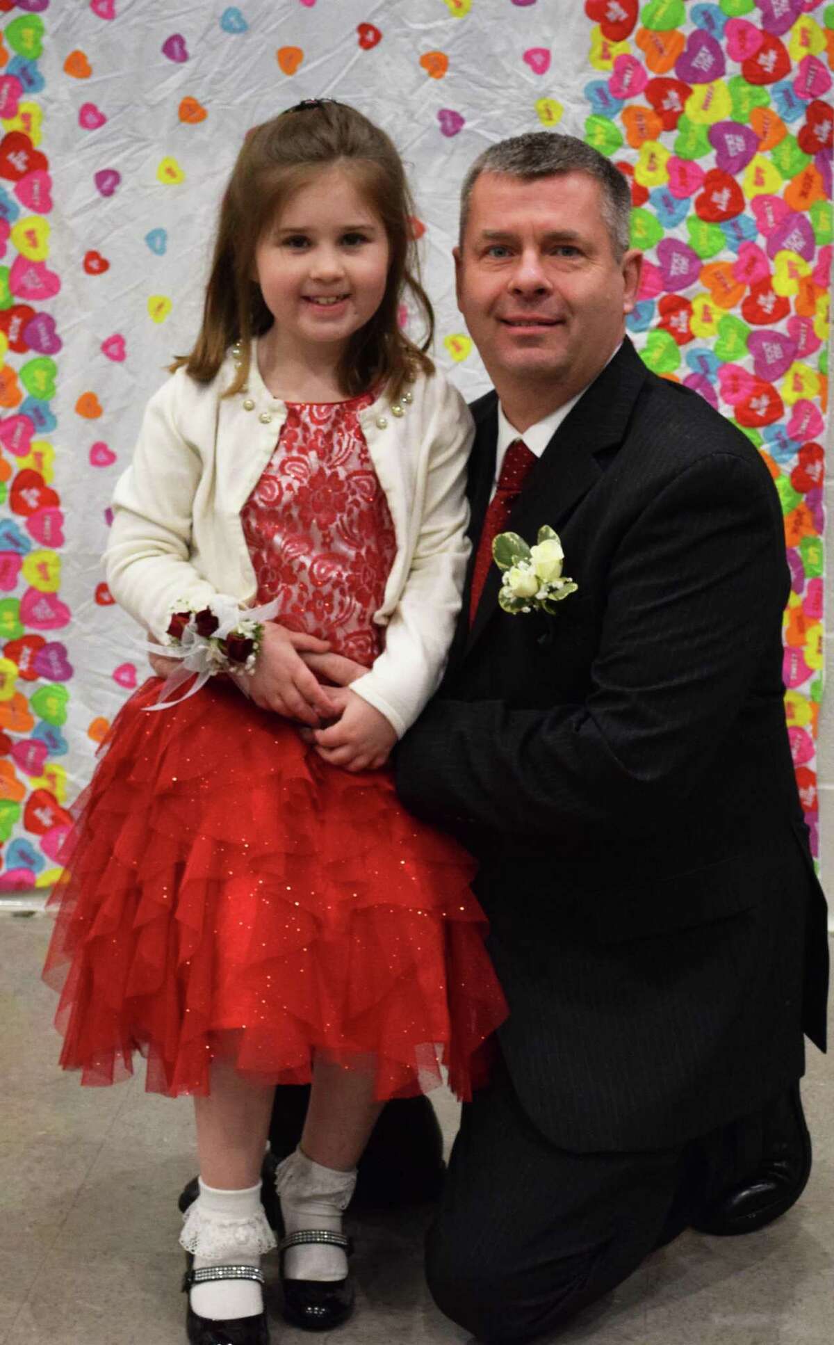 Spectrum/Rob Dempster and his daughter, Eleanor, 7, pause to have their photo taken at the start of the New Milford Girl Scouts annual Sweetheart Dance, sponsored this year by Troop 40236, at New Milford High School Feb. 9, 2018.