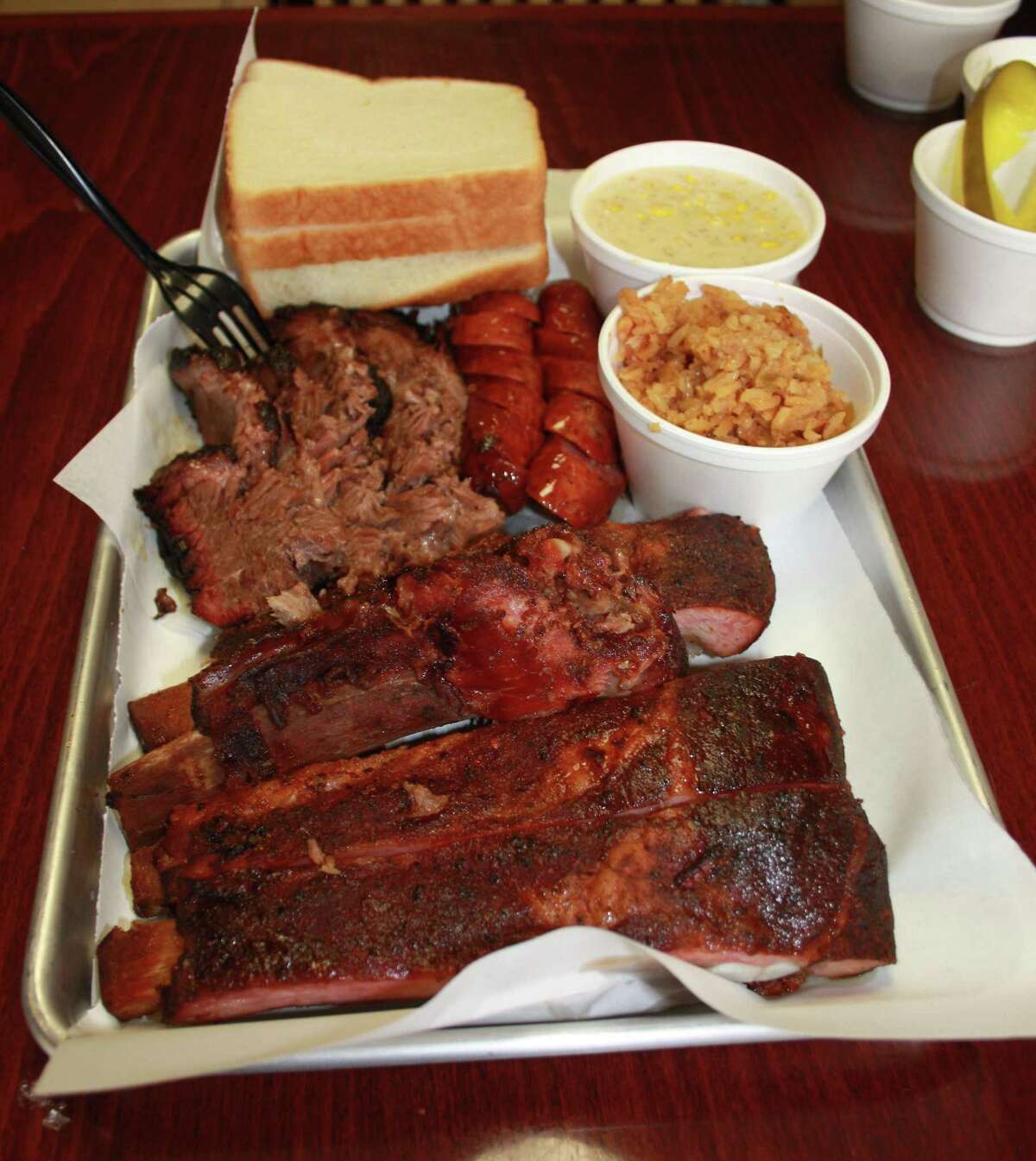The El Monte BBQ menu keeps it simple with pork spare ribs, sausage and brisket as the only meat options. Sides include Spanish rice, creamed corn, potato salad and (not pictured) baked beans.