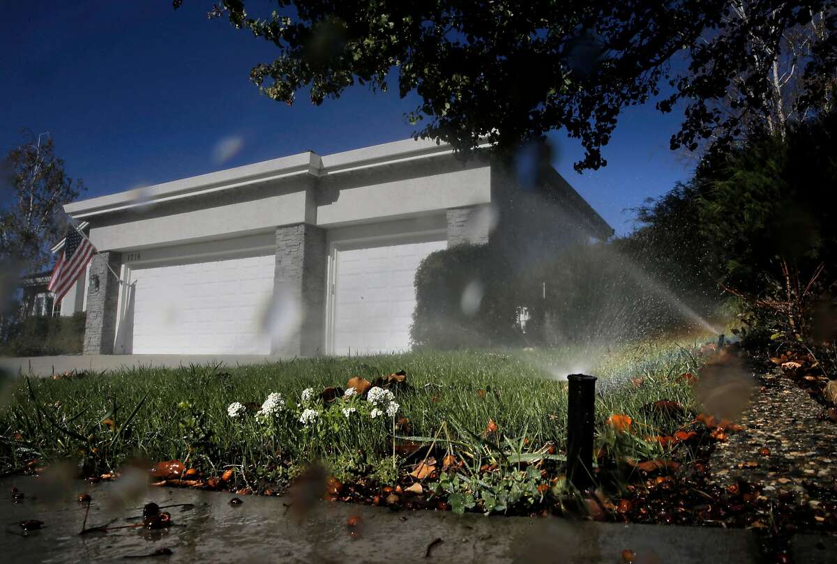 Sprinklers water a lawn at noon in the city of Pleasanton, on November 4, 2015.