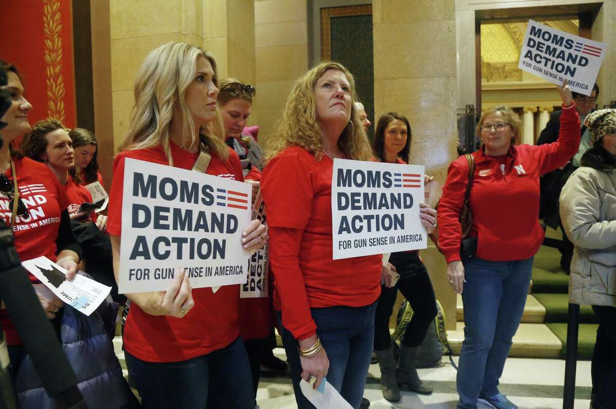 Moms Demand Actions rally outside the Minnesota House Chamber Tuesday, Feb. 20, 2018 in St. Paul, Minn. as they called on lawmakers to expand background checks and resist efforts to widen the state's gun laws after the school shooting in Florida last week that killed 17 students and teachers. (AP Photo/Jim Mone)