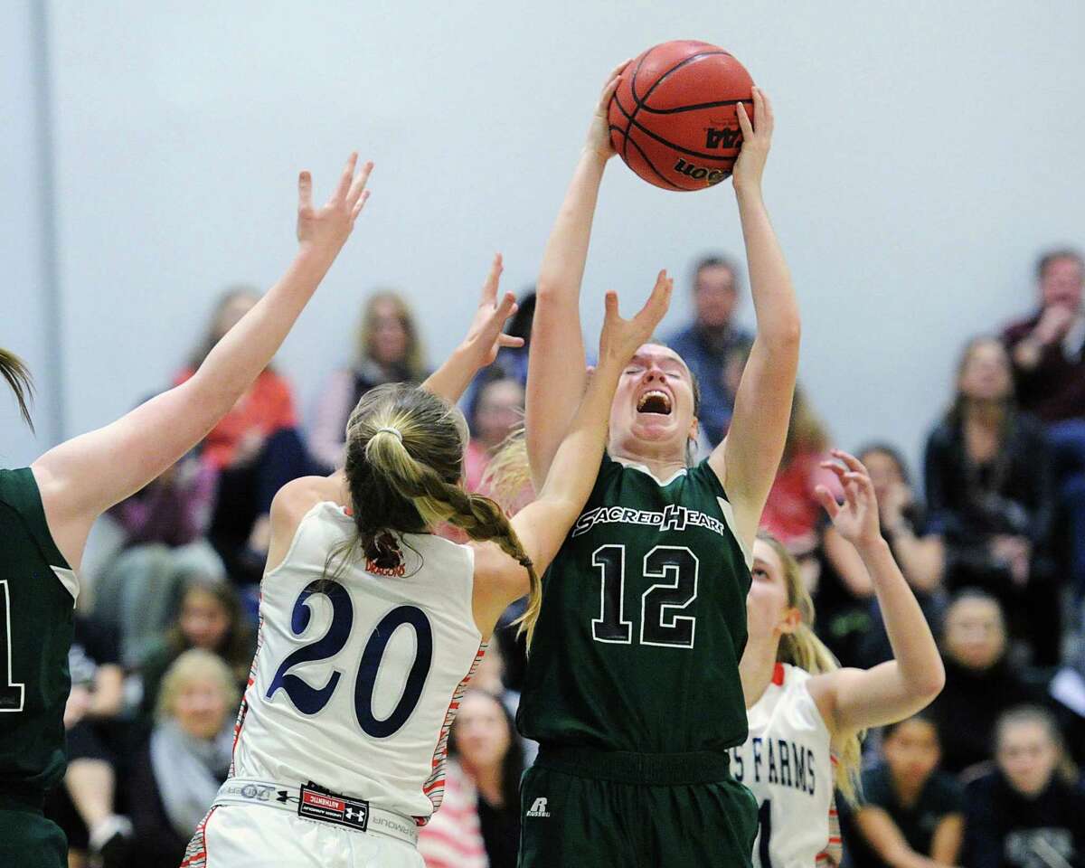 Sacred Heart’s Claire Liddy, right, grabs an offensive rebound over Greens Farms Academy’s Kelly Van Hoesen during the FAA quarterfinal game on Tuesday in Greenwich.