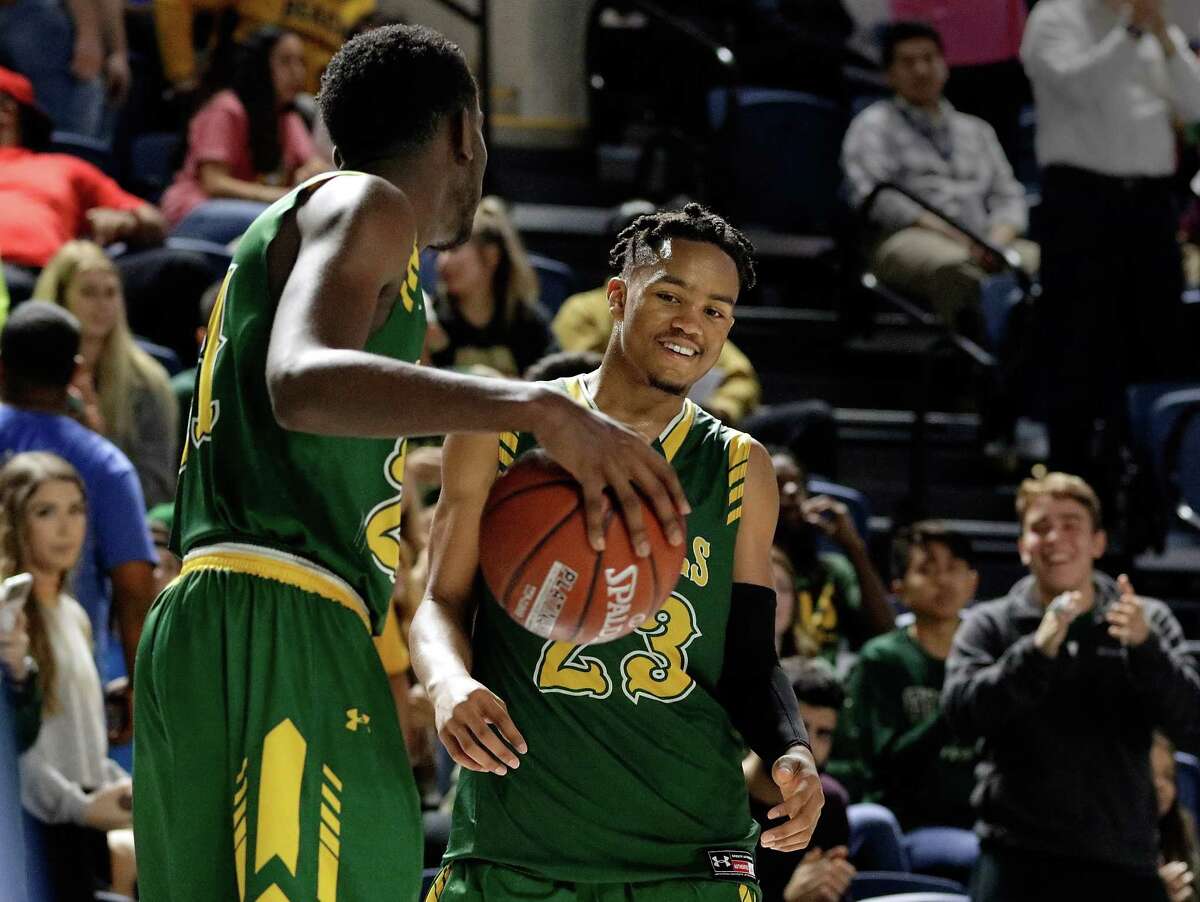 Cy Falls' Kendall Scott and Nigel Hawkins dribble and grin as they wind down the final seconds on the clock of their win against Bellaire in the Bi-District playoffs at Delmar Field House in Houston, TX, Feb. 20, 2018. (Michael Wyke / For the Chronicle)