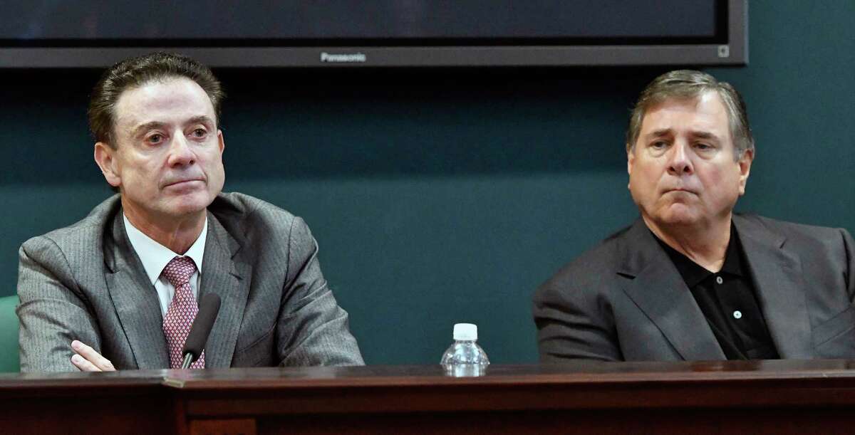 FILE - In this Oct. 20, 2016, file photo, University of Louisville head basketball coach Rick Pitino, left, and Athletic Director Tom Jurich listen during a press conference, in Louisville, Ky. Louisville must vacate its 2013 menÂ?’s basketball title following an NCAA appeals panelÂ?’s decision to uphold sanctions against the menÂ?’s program for violations committed in a sex scandal. The Cardinals will have to vacate 123 victories including the championship, and return millions in postseason revenue. The decision announced on Tuesday, Feb. 20, 2018, by the governing bodyÂ?’s Infraction Appeals Committee ruled that the NCAA has the authority to take away championships for what it considers major rule violations. (AP Photo/Timothy D. Easley, File)