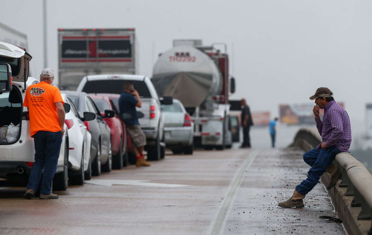 Motorists wait for the westbound lanes of Interstate 10 to be re-opened after an 18-wheeler crashed near the Monmouth Drive exit Wednesday, Feb. 21, 2018, in Houston.
