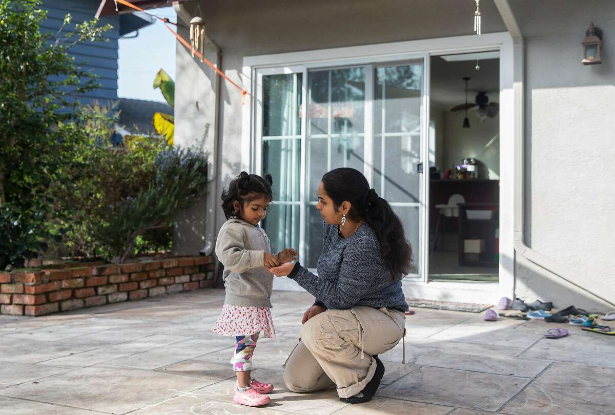 Renuka Sivarajan solves a problem with Sanjana, 3, Wednesday, Jan. 17, 2018 in the backyard of her home and day care center in Fremont, Calif.