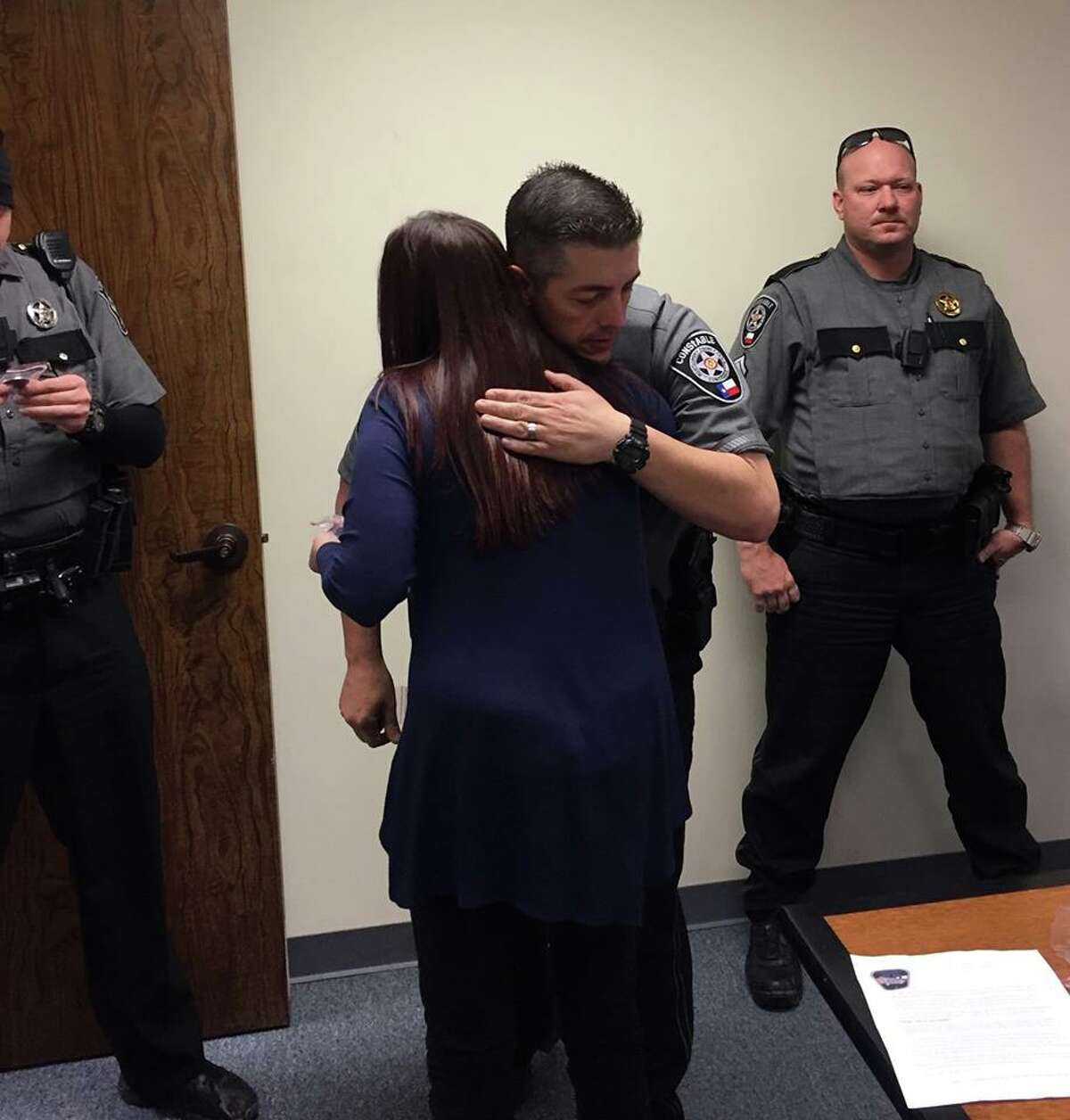 Samantha Bachman recevives a hug from Montgomery County Precinct 4 Constable's Lieutenant Buck Clendennen after presenting the office with Challenge Coins through her project, "One Coin at a Time."