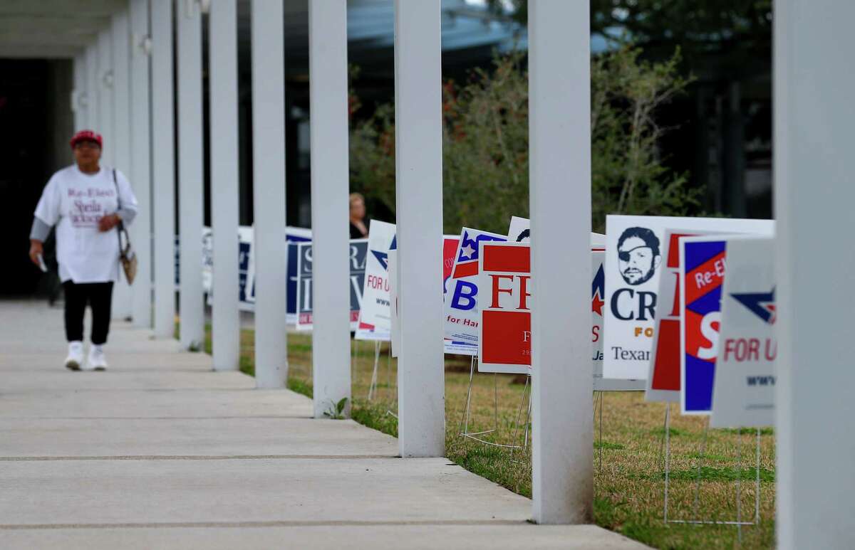 Campaign signs aligned with the walkway that leads to the front door of the early voting station at the Metropolitan Multi-Services Center Tuesday, Feb. 20, 2018.
