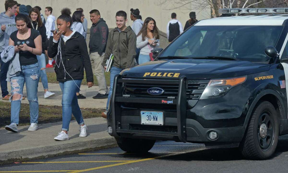 Norwalk High School students exit the school following a report of a student with a gun put the school on "shelter" alert Tuesday, February 20, 2018, in Norwalk, Conn.