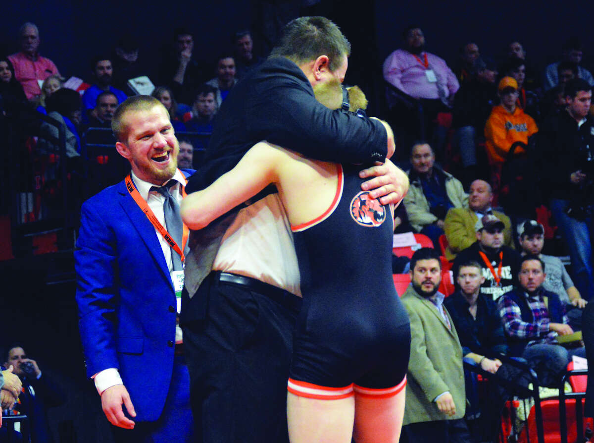 Edwardsville coach Jon Wagner hugs junior Noah Surtin after the state championship match of the 113-pound bracket on Saturday at the State Farm Center in Champaign.