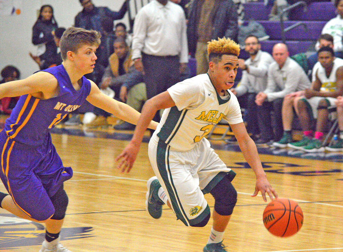 Metro-East Lutheran junior Jason Williams, right, drives past a Mount Olive player during Wednesday's semifinal game at the Class 1A Mount Olive Regional.