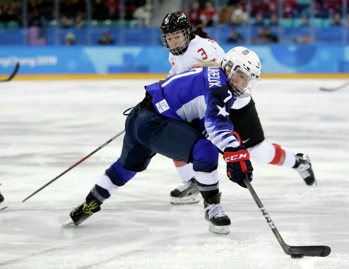 Monique Lamoureux-Morando (7), of the United States, skates with the puck against Jocelyne Larocque (3), of Canada, during the first period of the women's gold medal hockey game at the 2018 Winter Olympics in Gangneung, South Korea, Thursday, Feb. 22, 2018.