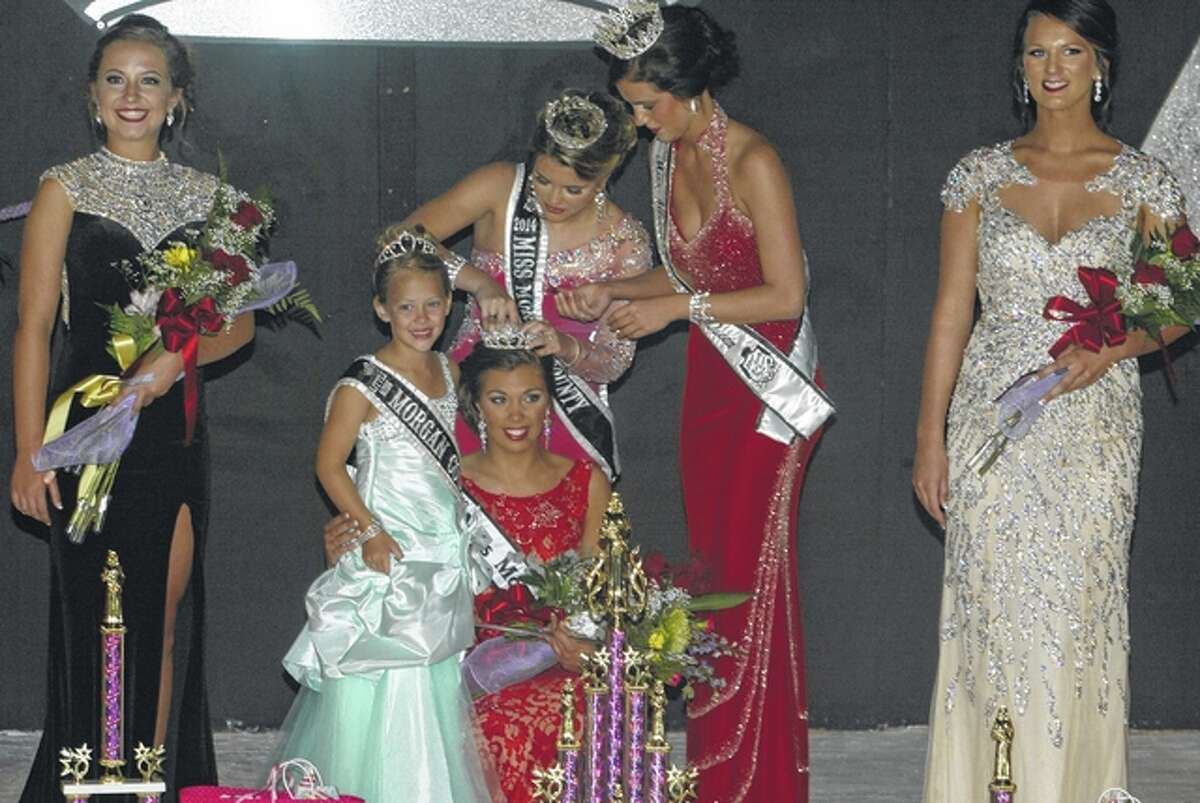 Nick Draper | Journal-Courier Abby Tomhave, daughter of John and Sherri Tomhave of Jacksonville, is crowned Morgan County Fair Queen by 2014 Morgan County Fair Queen Brianna Klein at the Morgan County Fair on Wednesday.