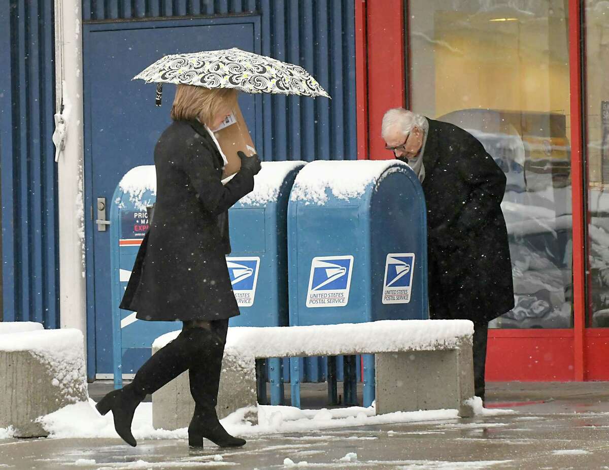A women uses an umbrella as she carries a package into the post office at Stuyvesant Plaza during a snow storm on Thursday, Feb. 22, 2018 in Guilderland, N.Y. (Lori Van Buren/Times Union)