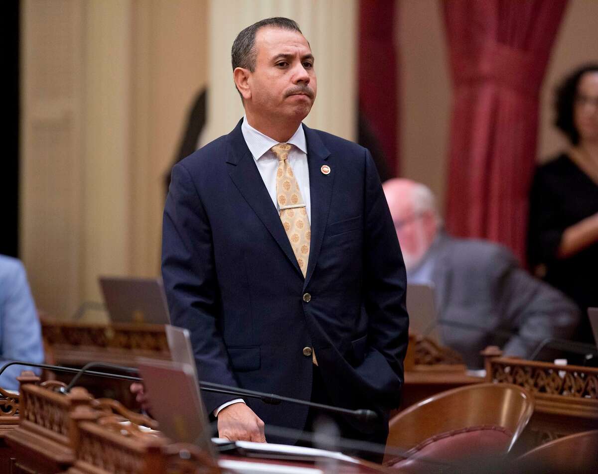 FILE - In this Jan. 3, 2018 file photo, Sen. Tony Mendoza, D-Artesia, stands at his desk after announcing that he will take a month-long leave of absence while an investigation into sexual misconduct allegations against him are completed during the opening day of the Senate in Sacramento, Calif. The Senate Rules Committee announced, Friday, Feb. 16, that an independent investigation conducted by an outside law firm has been completed and the committee could recommend disciplinary action as soon as Tuesday, Feb, 20. (AP Photo/Steve Yeater, File)