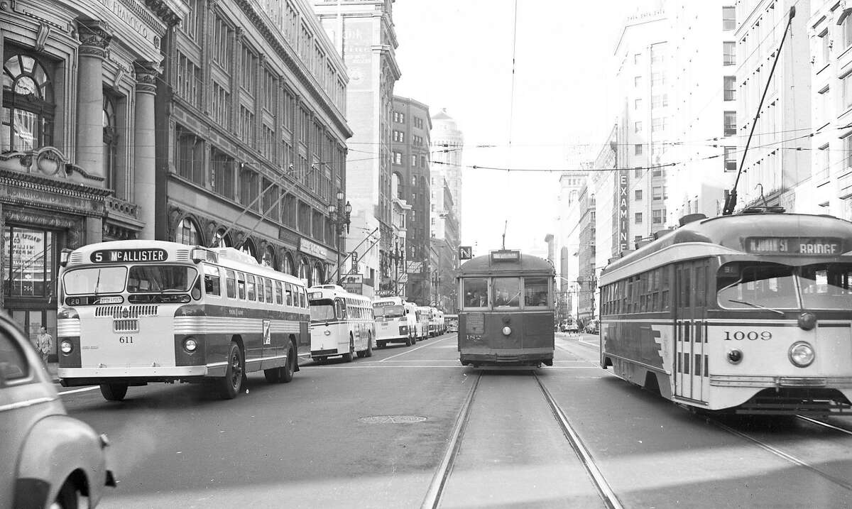 The new Municipal Railway electric "trackless trolley" bus (left) makes its official debut on Market Street in San Francisco on July 5, 1949.