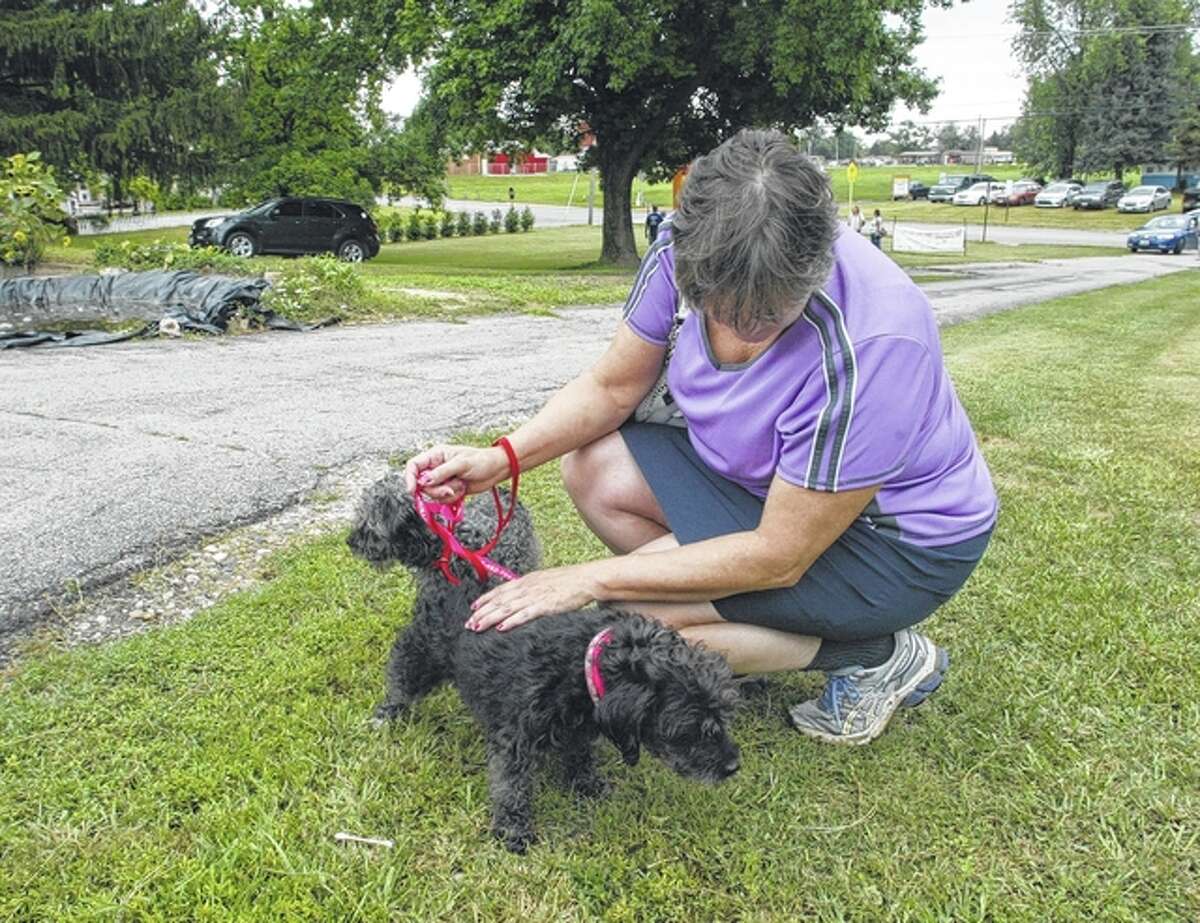 Jan Foehner of Springfield gets to know the two dogs — Mickey and Minnie — that she adopted Saturday from the Protecting Animal Welfare Society in Jacksonville during the organization’s fifth annual Dog Gone Fun-raiser. Minnie is the dark-colored pooch.