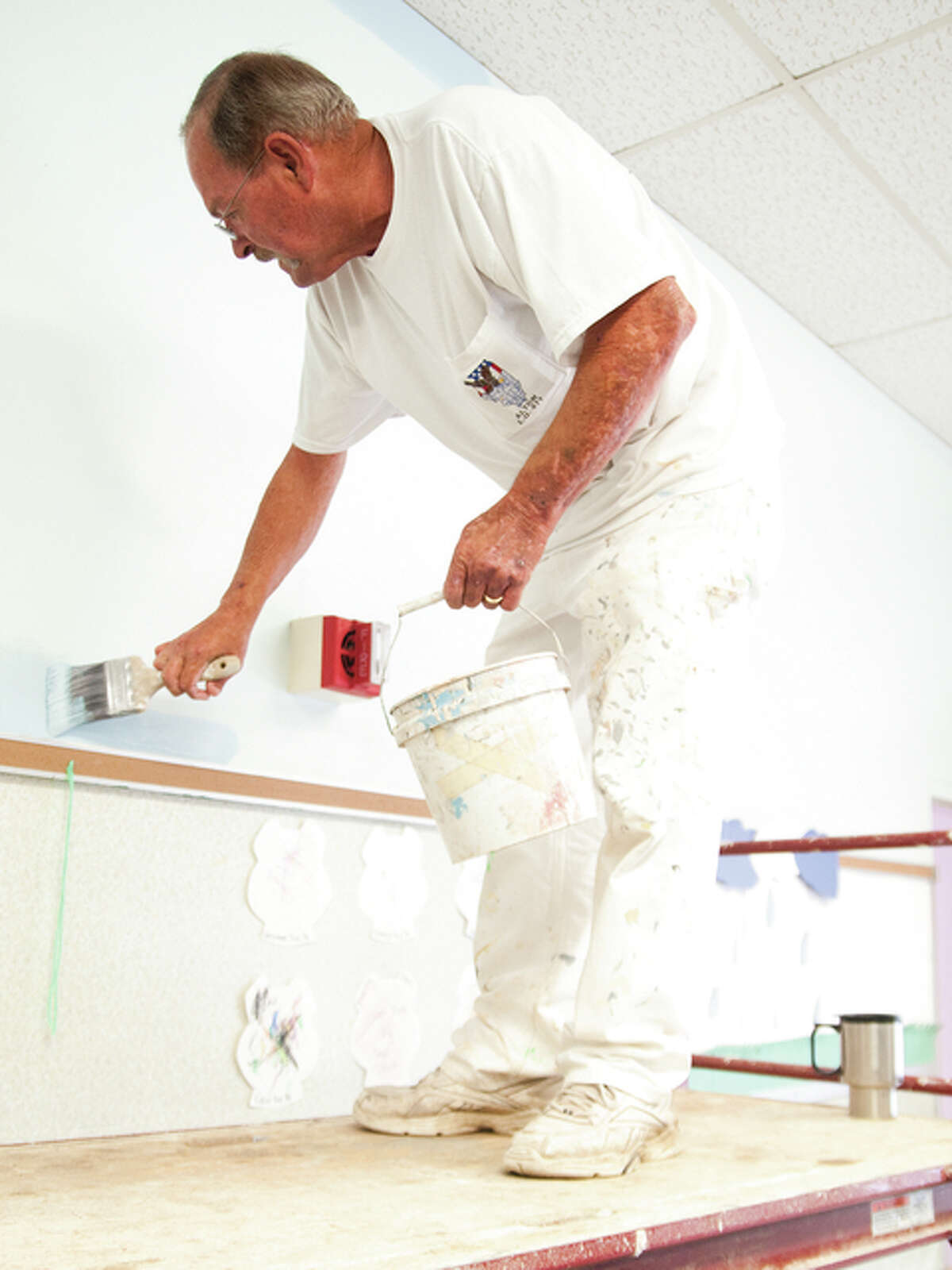 Cy Austin volunteered his time to help paint one of the rooms on Saturday morning at the Alton Day Care Center-Mckinley Site.