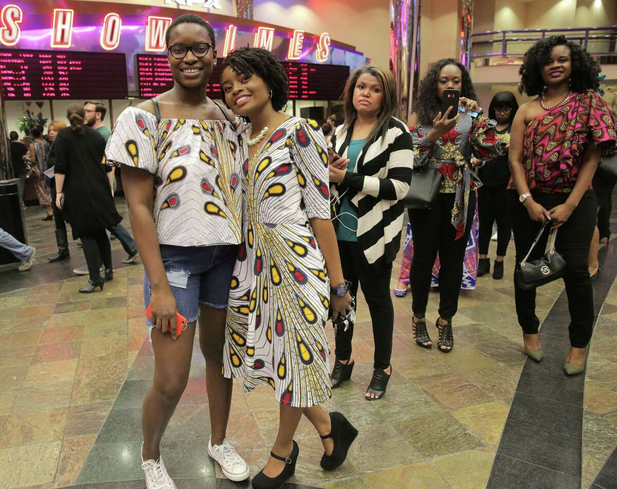 Daisy Umotong, right, and Dozie Oheri pose for a photo in their matching patterned shirt and dress. The two never met before they saw eachother in the same pattern, Umotong bought her dress on Etsy, Oheri bought her shirt at a pop-up shop in Houston. Movie goers line up to watch Black Panther at Edwards Theater Greenway Plaza on Thursday, Feb. 15, 2018, in Houston. ( Elizabeth Conley / Houston Chronicle )