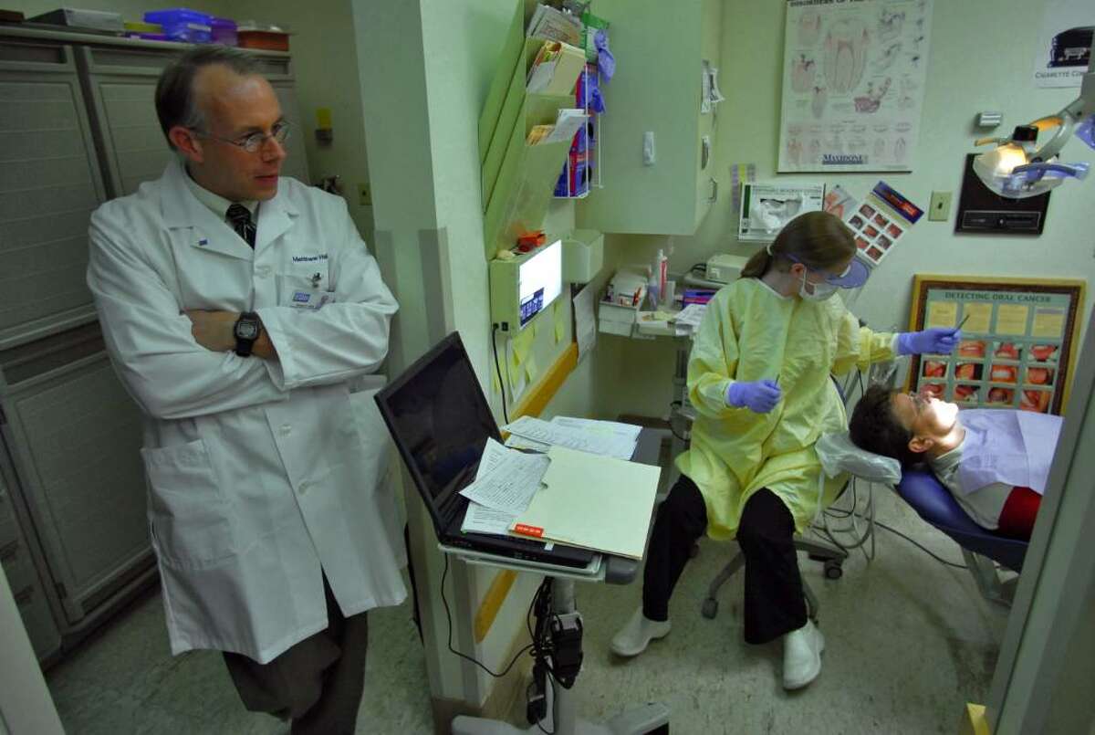 he old Dental Health Center is soon to be moved from its current basement location to an enhanced location with much more space and more treatment rooms, on the first floor of the new Ellis Health Center in Schenectady, NY Thursday November 12, 2009. Matthew Hall, D.D.S., left, looks in on dental assistant Alison Gibney as she works with patient Karen Trethaway in the current center. The overall facility is the former St. Clare's Hospital. ( Philip Kamrass / Times Union)