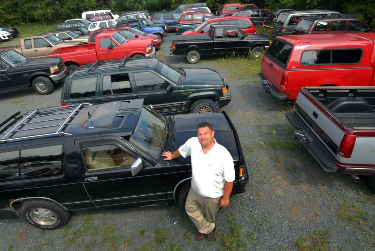 Sales Manager Hal Talbot of Cooley Motors stands with recently traded-in vehicles in the Cash for Clunkers program in Rensselaer. (Michael P. Farrell / Times Union )