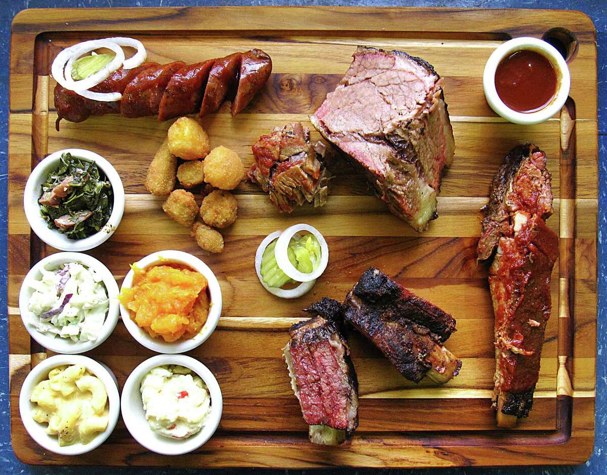 Meat and sides from The Rib House. Clockwise from top left: sausage, brisket, barbecue sauce, pork spare rib, beef short ribs, potato salad, mac and cheese, cole slaw, collard greens, fried okra, corn nuggets and yams.