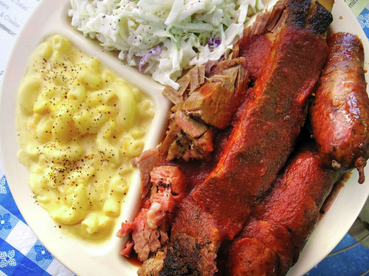 A three-meat plate with a pork rib, brisket, sausage, mac and cheese and cole slaw from The Rib House.