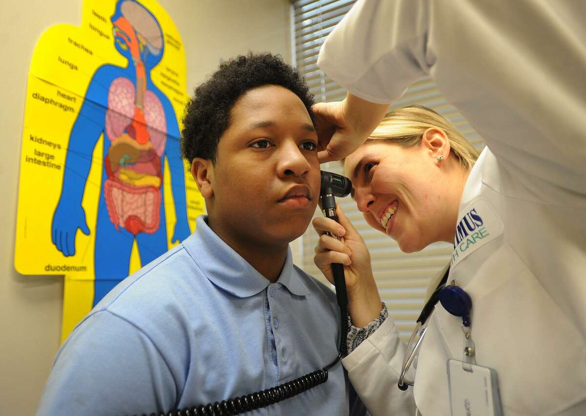 Recently recovered from the flu, fifth-grader Noah Joyner, 11, gets checked out by nurse Jessica Mauro, APRN, at the Optimus Health Clinic at Jettie Tisdale School in Bridgeport on Wednesday.