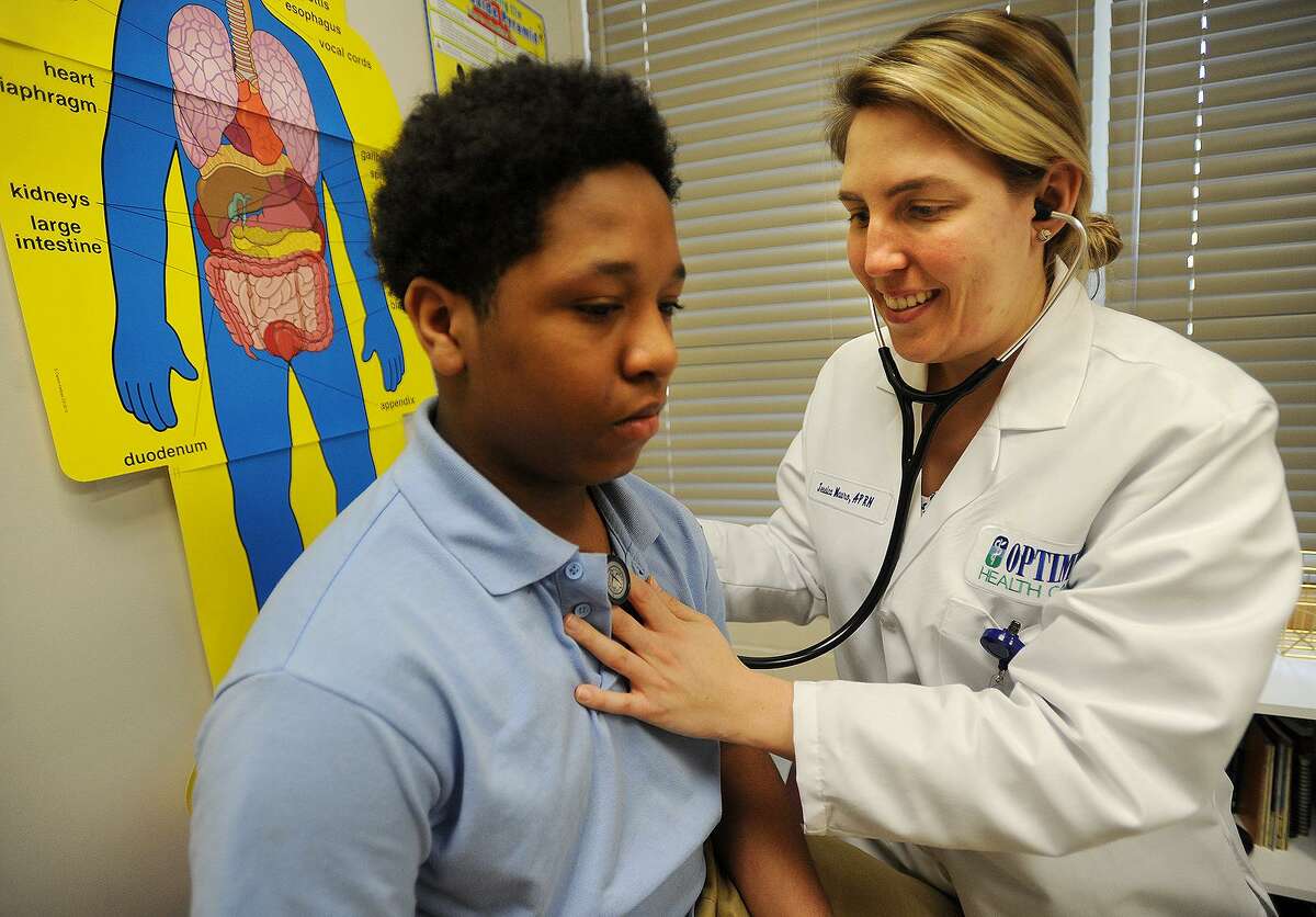 Recently recovered from the flu, fifth-grader Noah Joyner, 11, gets checked out by nurse Jessica Mauro, APRN, at the Optimus Health Clinic at Jettie Tisdale School in Bridgeport on Wednesday.