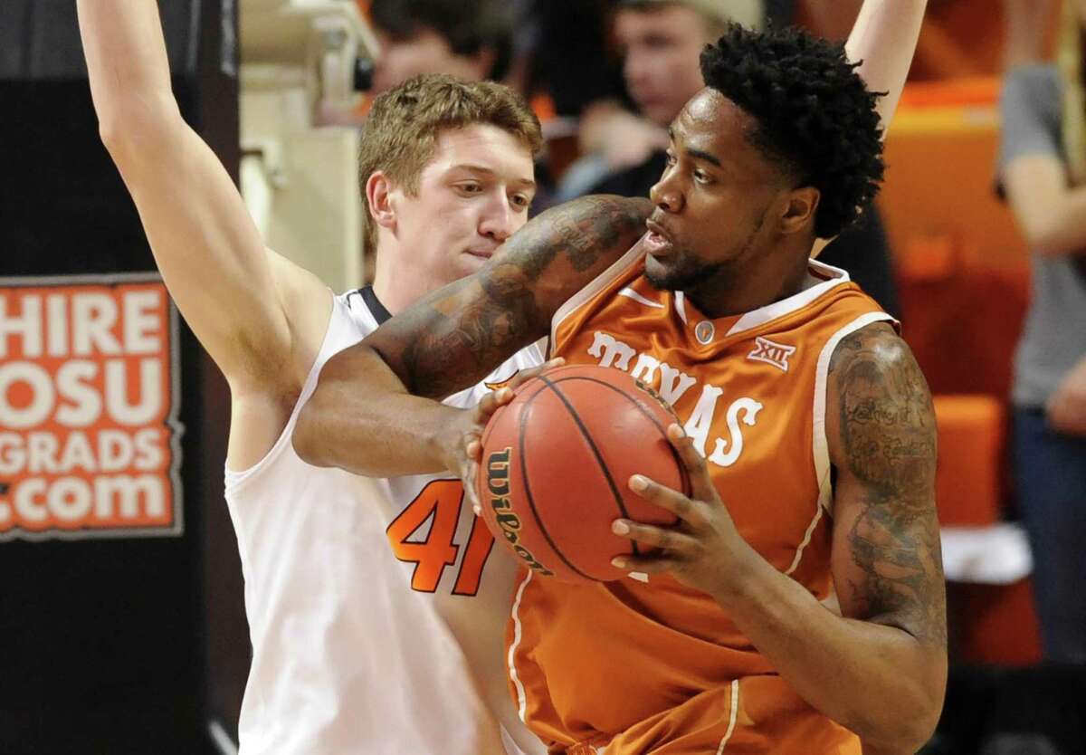Texas center Prince Ibeh, right, looks for a path around Oklahoma State forward Mitchell Solomon, in the first half of an NCAA college basketball game in Stillwater, Okla., Friday, March. 4, 2016. (AP Photo/Brody Schmidt)