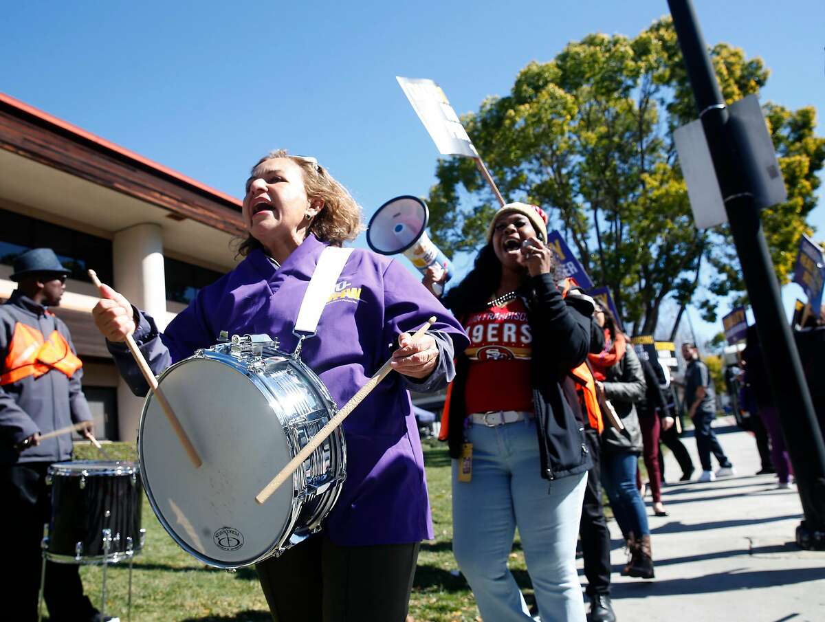 Marta Dominguez bangs on a drum as healthcare workers, concerned about job cuts and outsourcing, stage a rally outside of the Kaiser Permanente Medical Center in San Jose, Calif. on Friday, Feb. 23, 2018.