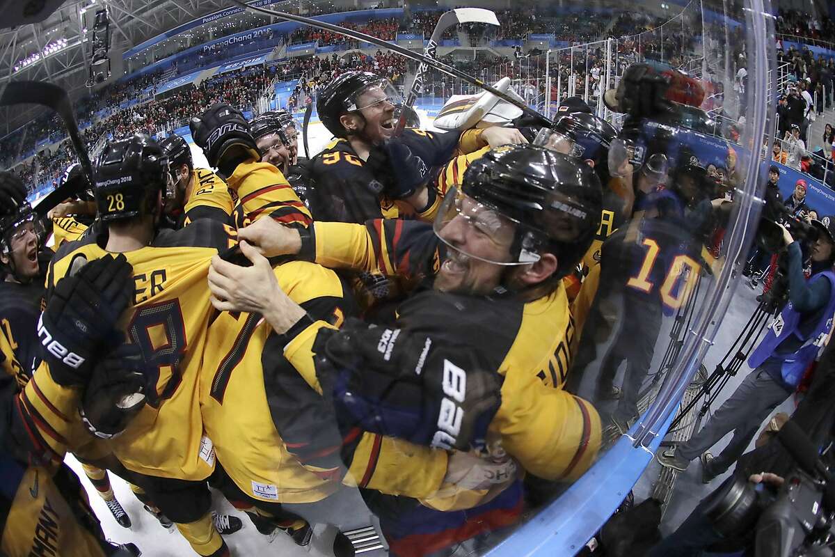 Germany players celebrate after the semifinal round of the men's hockey game against Canada at the 2018 Winter Olympics in Gangneung, South Korea, Friday, Feb. 23, 2018. Germany won 4-3. (AP Photo/Julio Cortez)