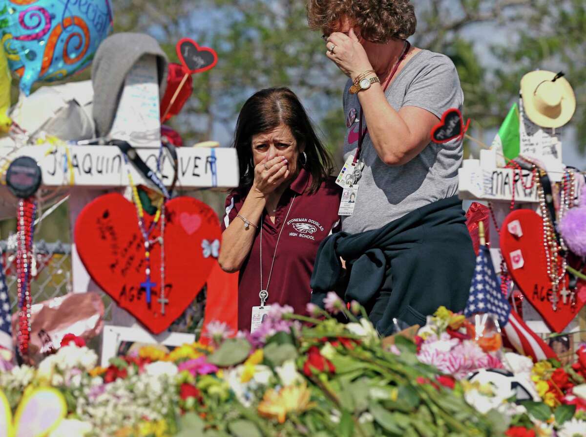 Marjory Stoneman Douglas High School administrative employees grieve after last week's deadly shooting at the school in Parkland, Fla. In Texas, Gov. Greg Abbott has called for a review of school safety procedures in the wake of the Parkland massacre.