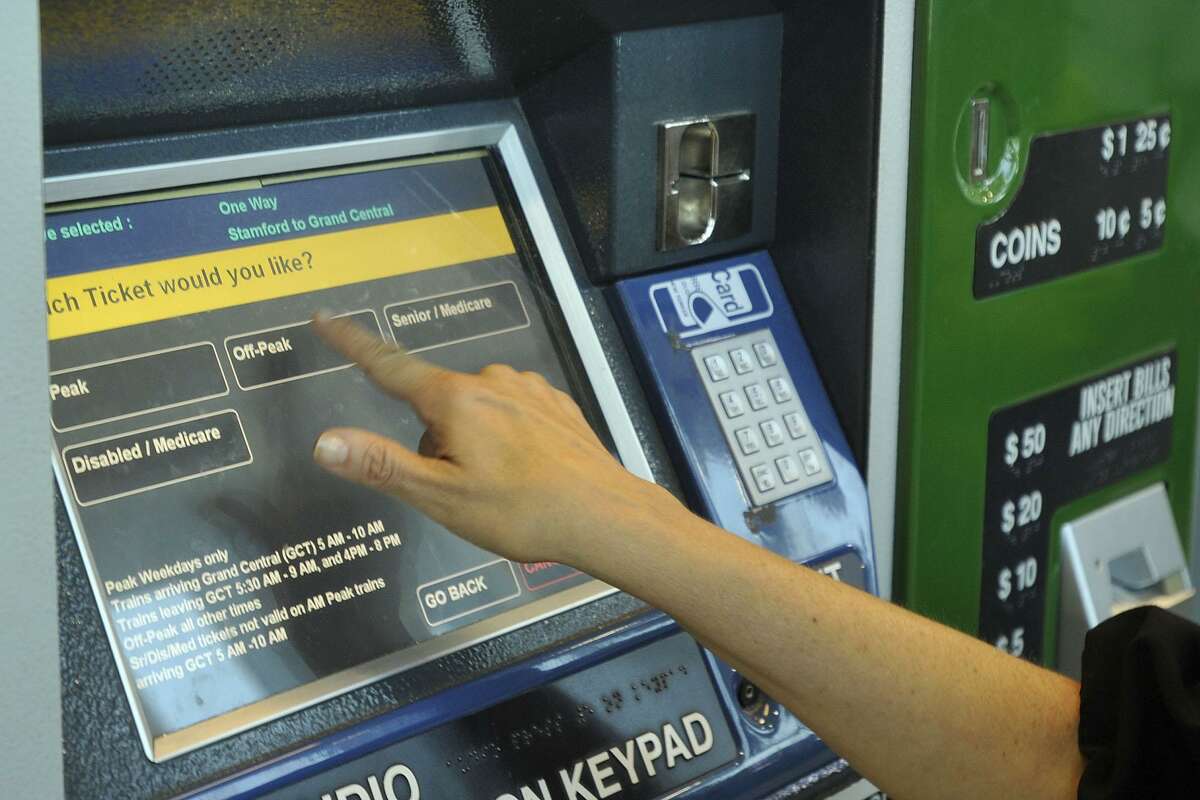 Lauran Epstein, a reverse commuter from New York City, purchases a Metro-North ticket at the Stamford train station in Stamford, Conn., on Tuesday, Aug. 5, 2014. Financial pressures including upcoming labor contracts, investments in safety and infastructure could mean at least a possible four percent rate increase for riders.