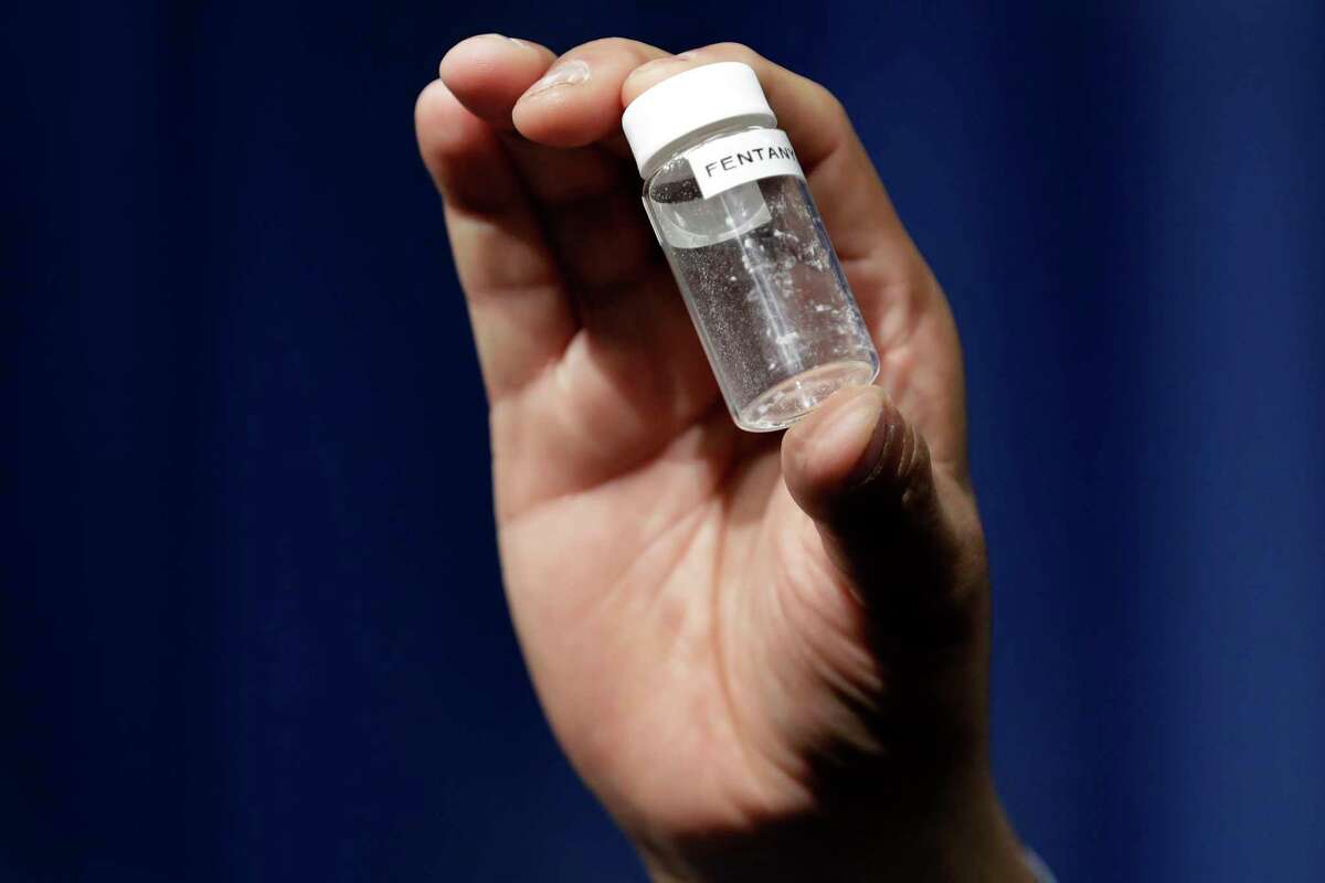 In this June 6, 2017 file photo, a reporter holds up an example of the amount of fentanyl that can be deadly after a news conference about deaths from fentanyl exposure.