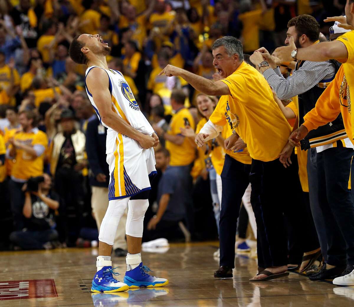 Golden State Warriors' Stephen Curry and Apple's Eddy Cue celebrates Curry's 3-pointer in final minute of 96-88 win over Oklahoma City Thunder in Game 7 of NBA Playoffs' Western Conference finals at Oracle Arena in Oakland, Calif., on Monday, May 30, 2016.