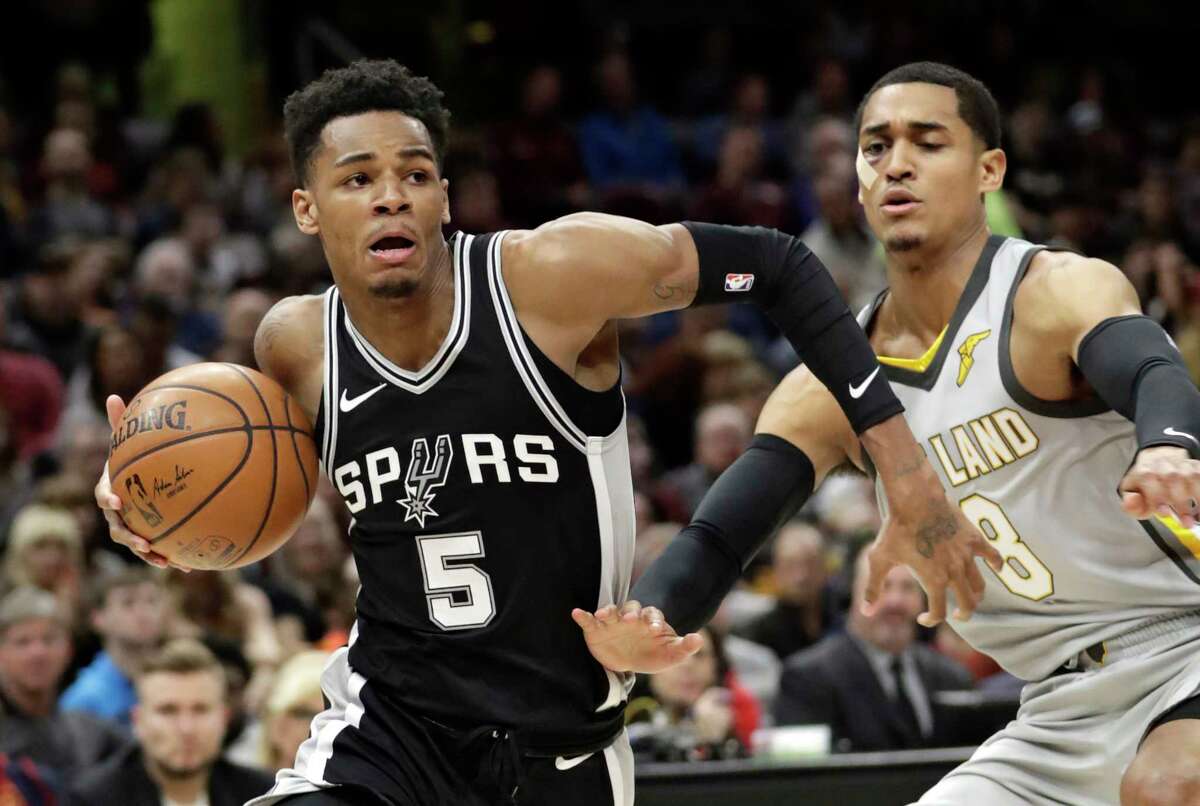 San Antonio Spurs' Dejounte Murray (5) drives past Cleveland Cavaliers' Jordan Clarkson (8) in the first half of an NBA basketball game, Sunday, Feb. 25, 2018, in Cleveland. (AP Photo/Tony Dejak)