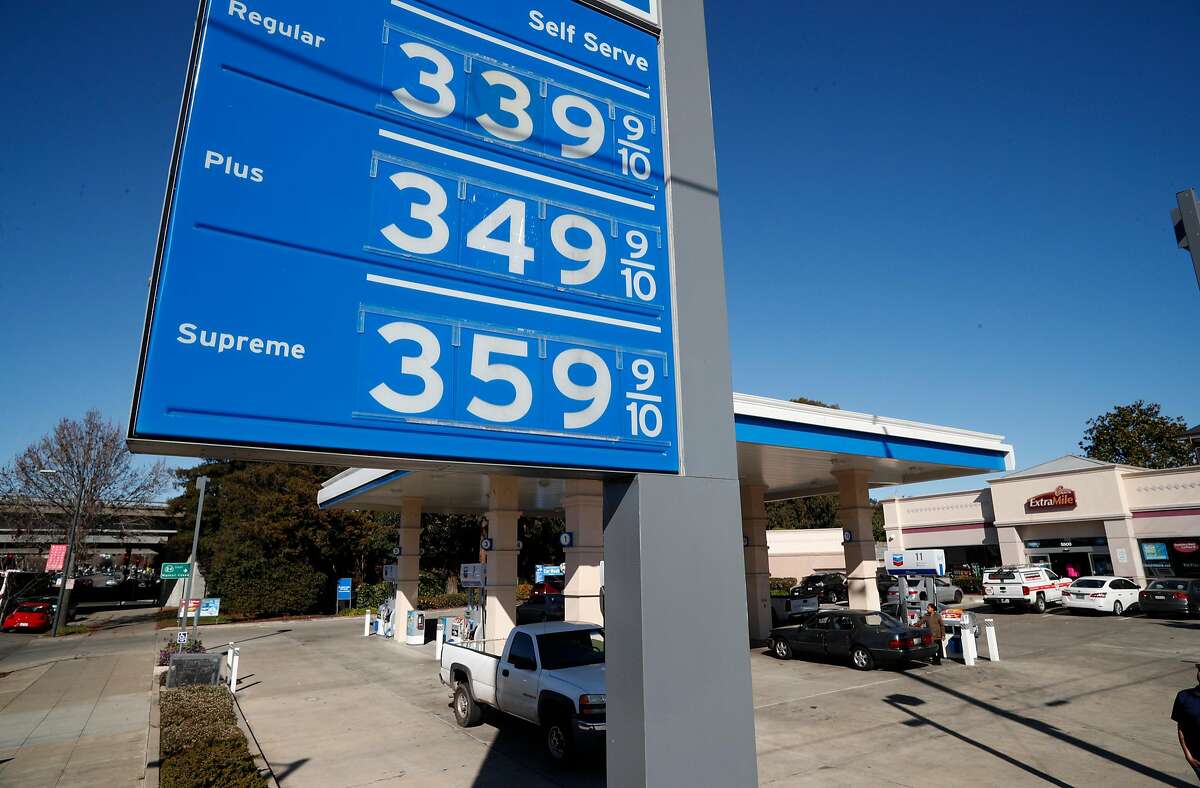People fill up their cars at a gas station in Oakland. The state recently hiked gas prices by 12 cents per gallon to fund road repairs.