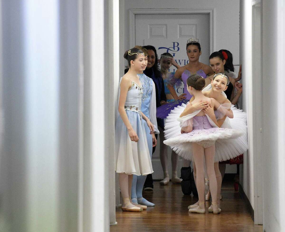Carolina Rivera hugs a young dancer as fellow dancers prepare to perform in a mini-showcase of the Greenwich Ballet Academy dancers on Saturday, Feb. 24, 2018 in Port Chester, New York. The dancers are preparing for the upcoming semi-finals for the YAGP competition, an international ballet competition held in Boston and New York.