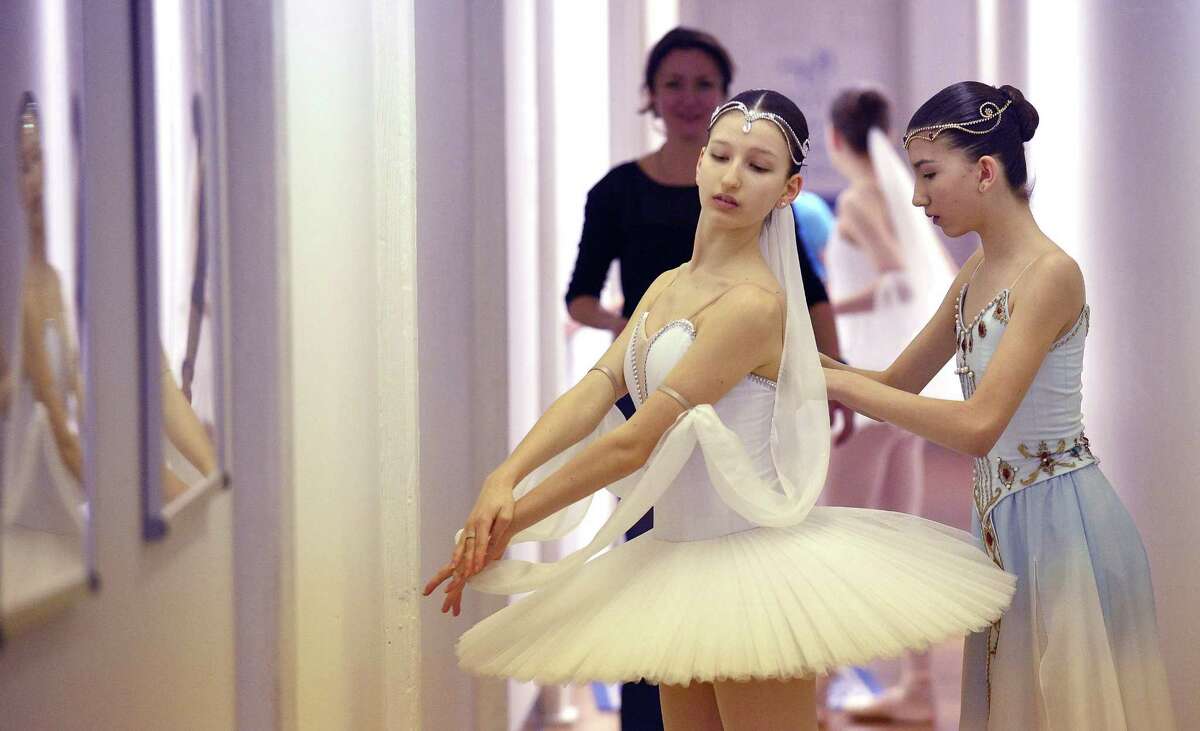 From left, Carolina Rivera is help with her costume by her twin sister Victoria Rivera as they prepare to perform solo routines during a mini-showcase of the Greenwich Ballet Academy dancers on Saturday, Feb. 24, 2018 in Port Chester, New York. The dancers are preparing for the upcoming semi-finals for the YAGP competition, an international ballet competition held in Boston and New York.