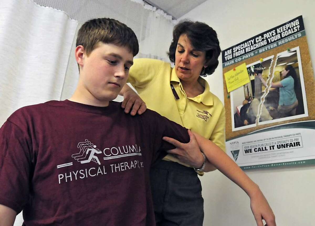 Physical Therapist Doreen Frank works with Maple Hill High School athlete Joe Chipman, 17, of Schodack, at Columbia Physical Therapy in East Greenbush. Physical therapy co-pays are rising and discouraging some patients from seeking care, but insurance industry advocates oppose legislation seeking caps. (Lori Van Buren/Times Union)