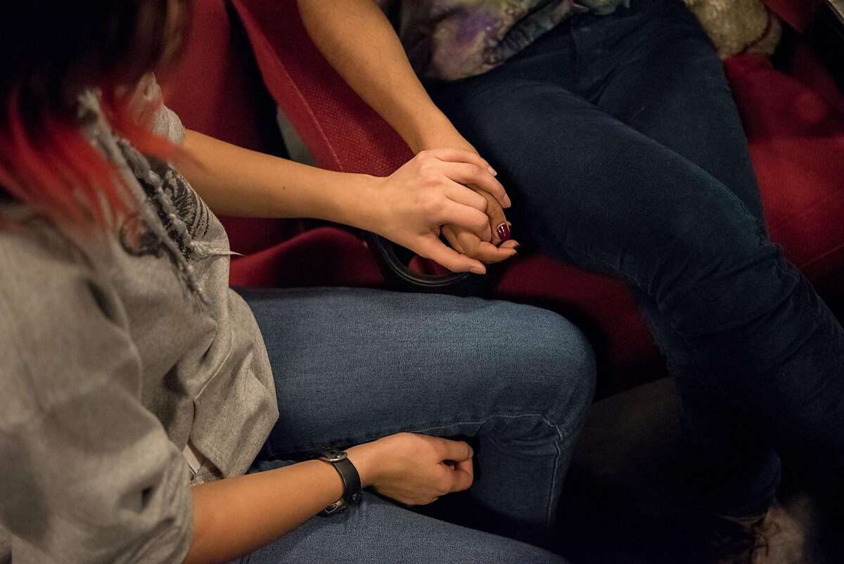Lick Wilmerding High School students Annette Vergara-Tucker, 16, and Olivia Jacob, hold hands as students discuss their experiences as LGBTQ teenagers, after the advance screening of �Love, Simon� in San Francisco on February 13, 2018.