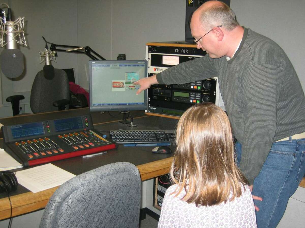 Chris Wienk, vice president for radio at WMHT Educational Telecommunications, shows Olive Niccoli the ropes. Olive, "almost 7," came into the WEXT studios to record her segment of the Peanut Butter Jam holiday special. Photo courtesy of Sara Niccoli