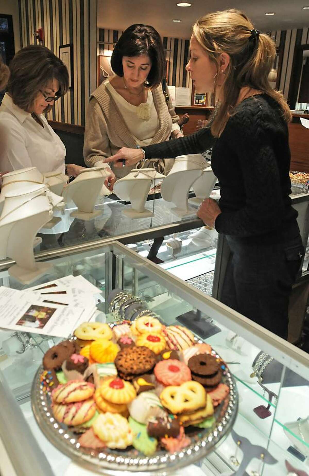 From left, Beverly Ryfa, of Glenmont, and Debra Belkin, of Niskayuna, shop for beads while employee Melissa Blood, of Albany, helps behind the counter at Drue Sanders Jewelry store in Guilderland on Oct. 23, 2009. This party's proceeds will go the the Autism Society of America. (Lori Van Buren / Times Union)