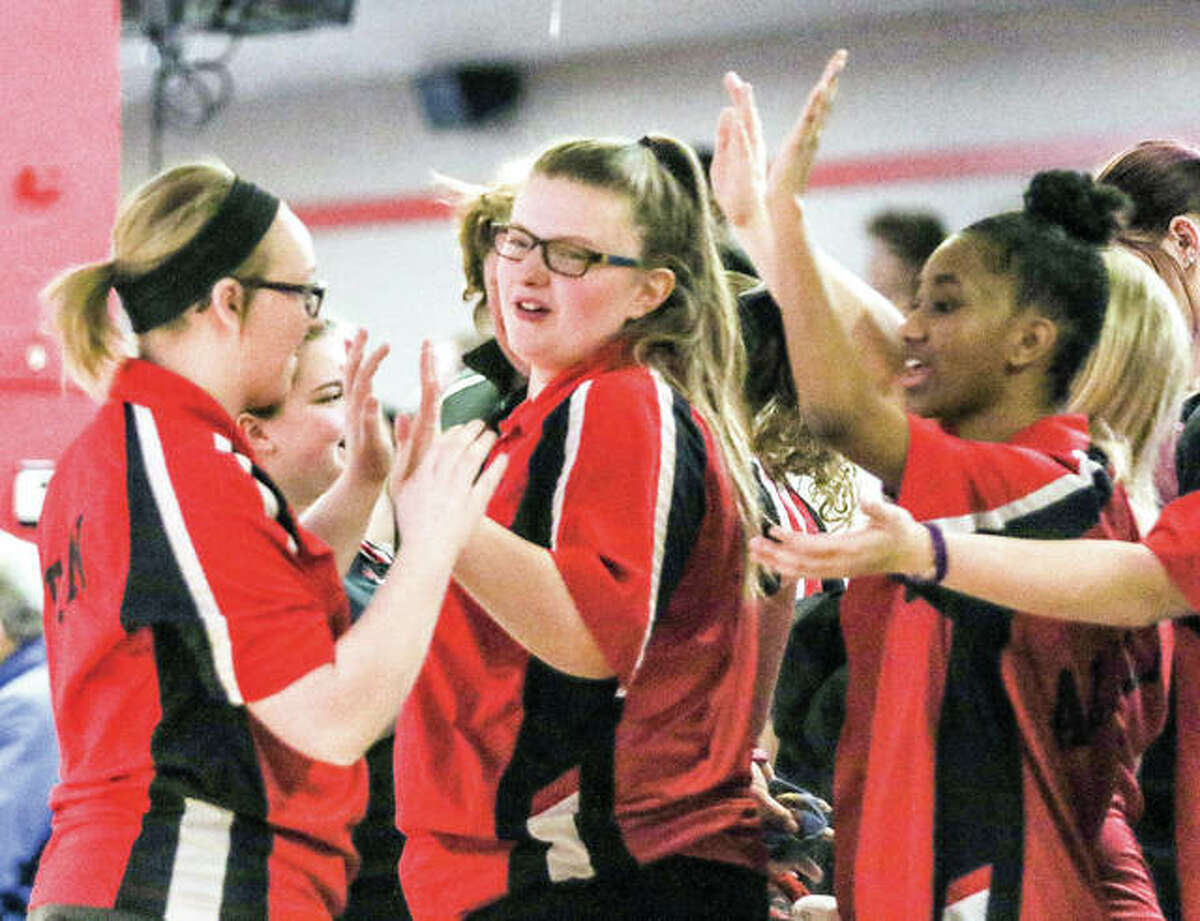 Alton junior Alex Bergin, center, is congratulated by teammates during Saturday’s IHSA Girls Bowling Regional Tournament at Bowl Haven in Alton. Bergin was the individual champion with 1,246 pins. She and her teammates captured the fourth spot in the team standings, qualifying the Redbirds for next week’s Mount Vernon sectional Tournament.