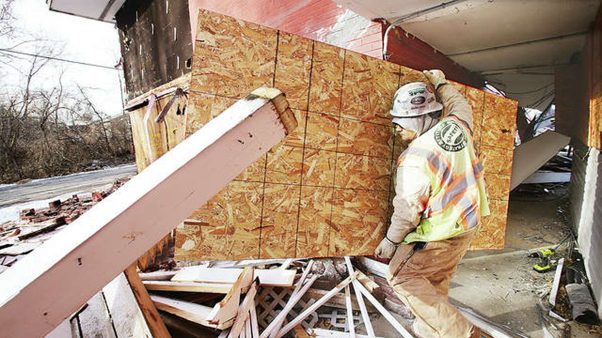 A worker Monday morning removes the boards that were covering the windows of the former Hiway House motel for months as he walks through the rubble which was a second floor set of stairs. It was one of the first things razed at the old multi-building motel.