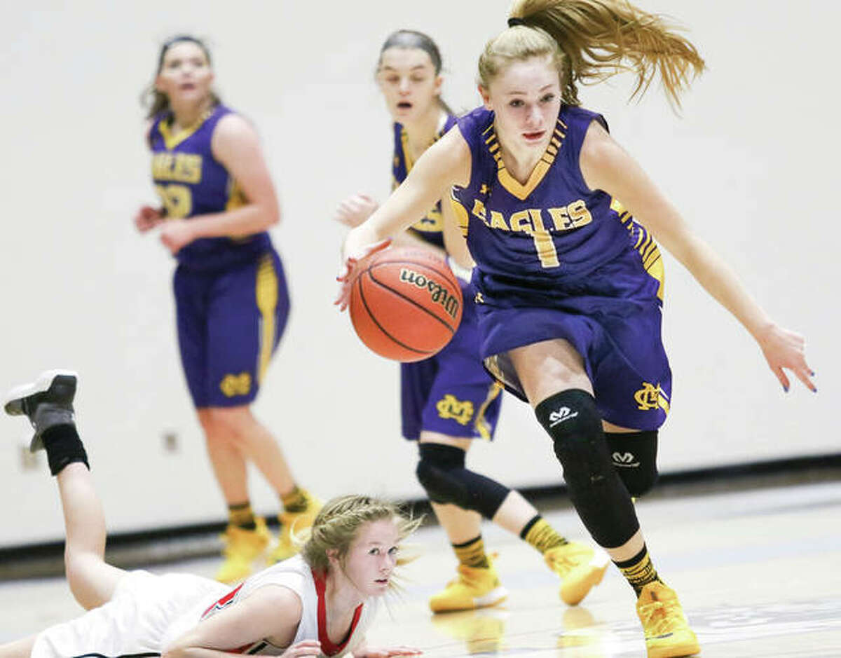 Civic Memorial’s Tori Standefer (1) heads upcourt as Calhoun’s Junie Zirkelbach (left) watches after falling to the court during play at the Jersey holiday tournament on Dec. 28 in Jerseyville. CM’s win Monday night at Mascoutah clinched the MVC title outright for the Eagles, while Calhoun preps for its Carrollton Class 1A Regional opener against Carrollton on Wednesday night.