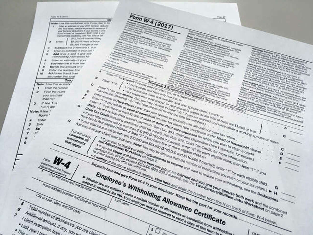 This photo shows an IRS W-4 form on Thursday, Feb. 1, 2018, in New York. Workers are starting to see more take-home pay as employers implement the new withholding guidelines from the IRS. How much extra cash depends on several factors, such as workers’ income, how often they are paid and the number of withholdings allowances they claim on their IRS Form W-4 with their employer.