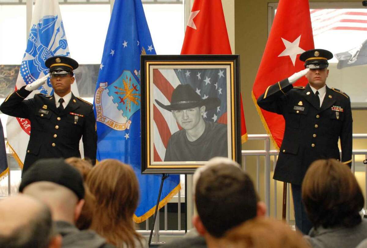 Honor guard members Jose Perez, left, and Pablo Rivera salute in front of the portrait of the late Sgt. David M. Fisher, who was killed while on patrol in Iraq on Dec. 1, 2004. Artist Phil Taylor of The American Fallen Soldier Project presented the portrait to Vicki DiMura during a ceremony at the New York State Division of Military and Naval Affairs in Latham. (Michael P. Farrell/Albany Times Union)