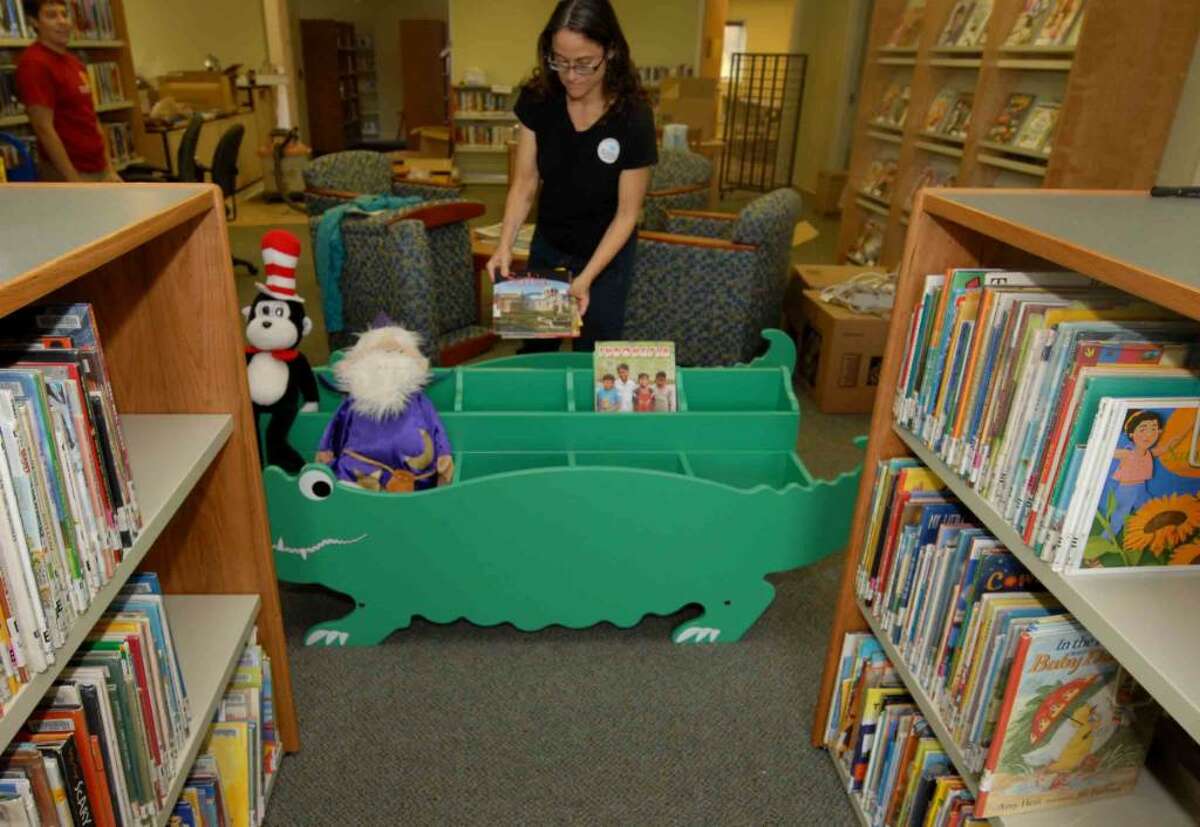 Brunswick Community Library Director Julie Zelman sets up the childrens book area at the library's new building in Brunswick. (Michael P. Farrell / Times Union ) The new library will open Saturday.